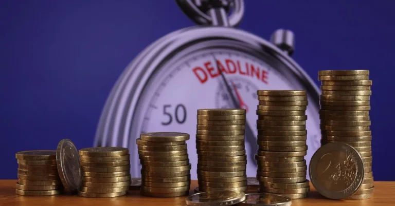 stack up coins and deadline word written in a clock